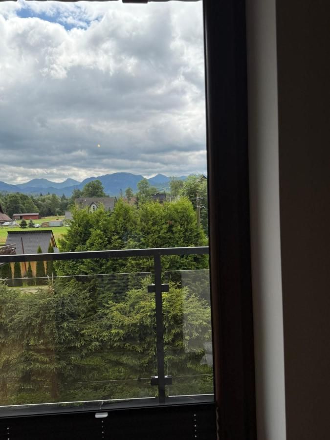 Widok na góry i zieleń przez drzwi balkonu